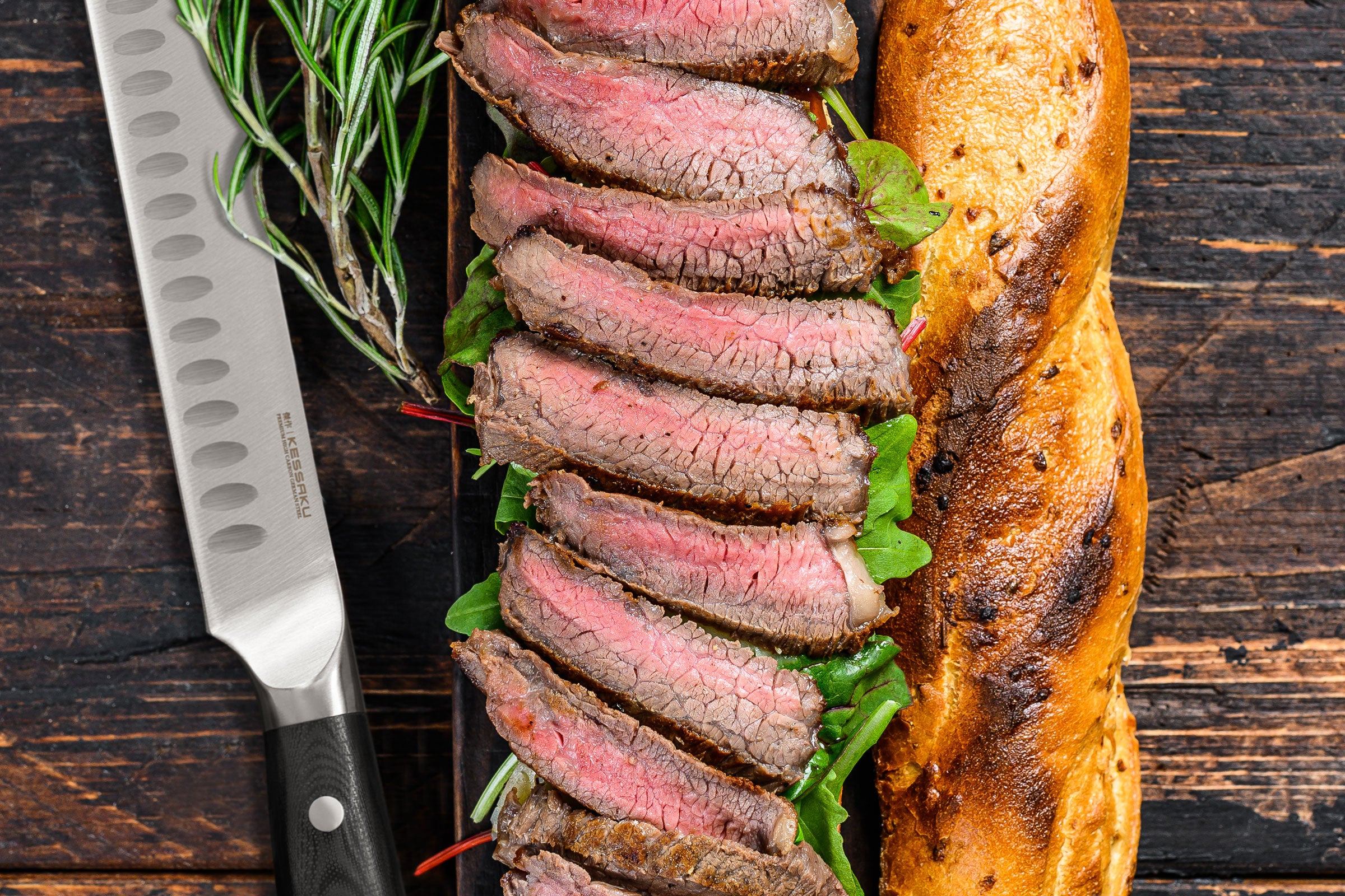 The Dynasty Carving Knife next to a sandwich with juicy steak slices.