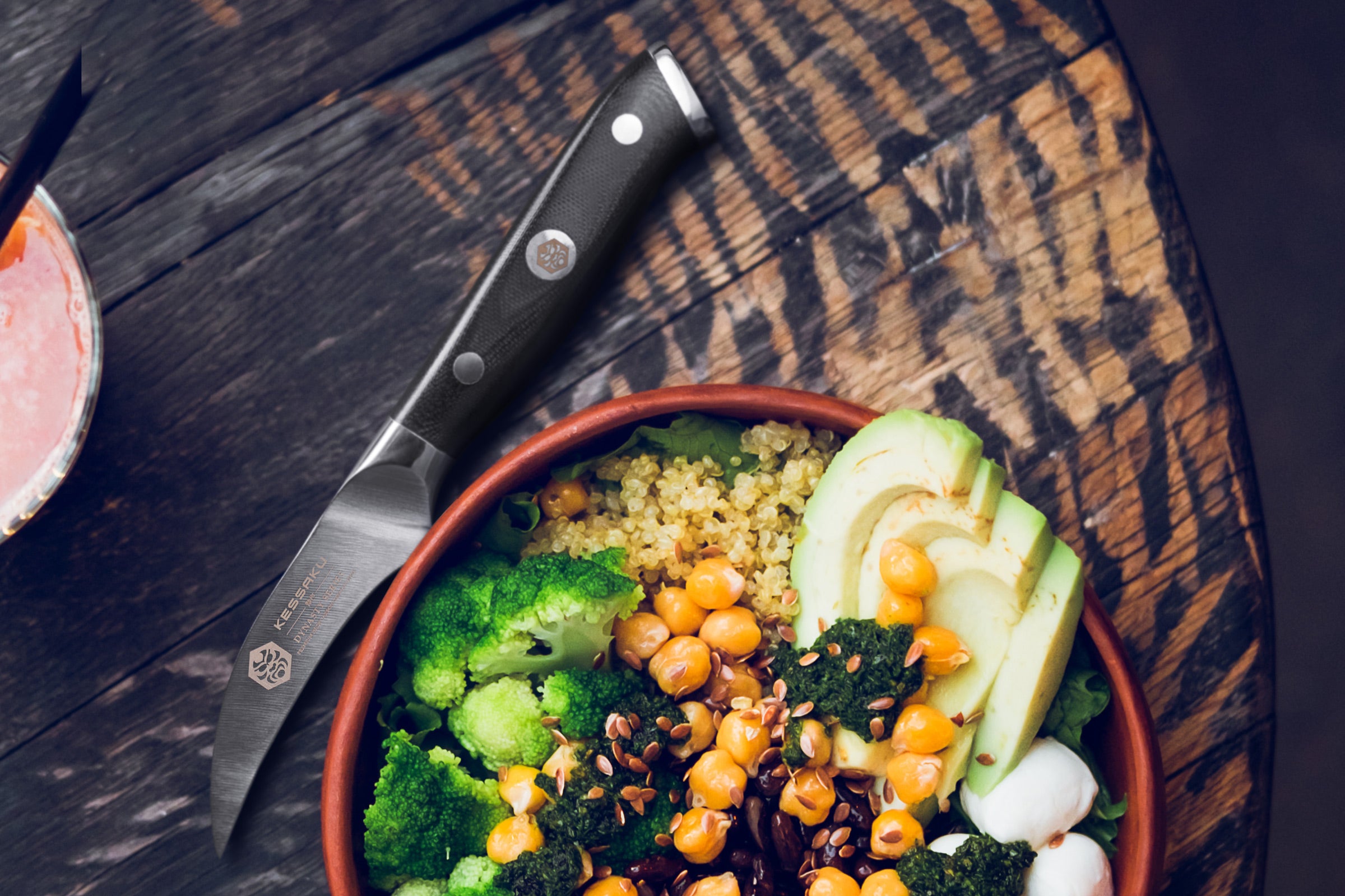 The Dynasty Bird's Beak Knife next to a bowl of chickpeas, avocado, broccoli, and more.