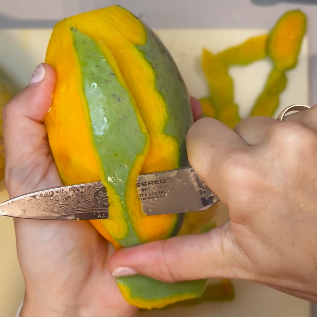 Danielle of Dani Made peels a mango