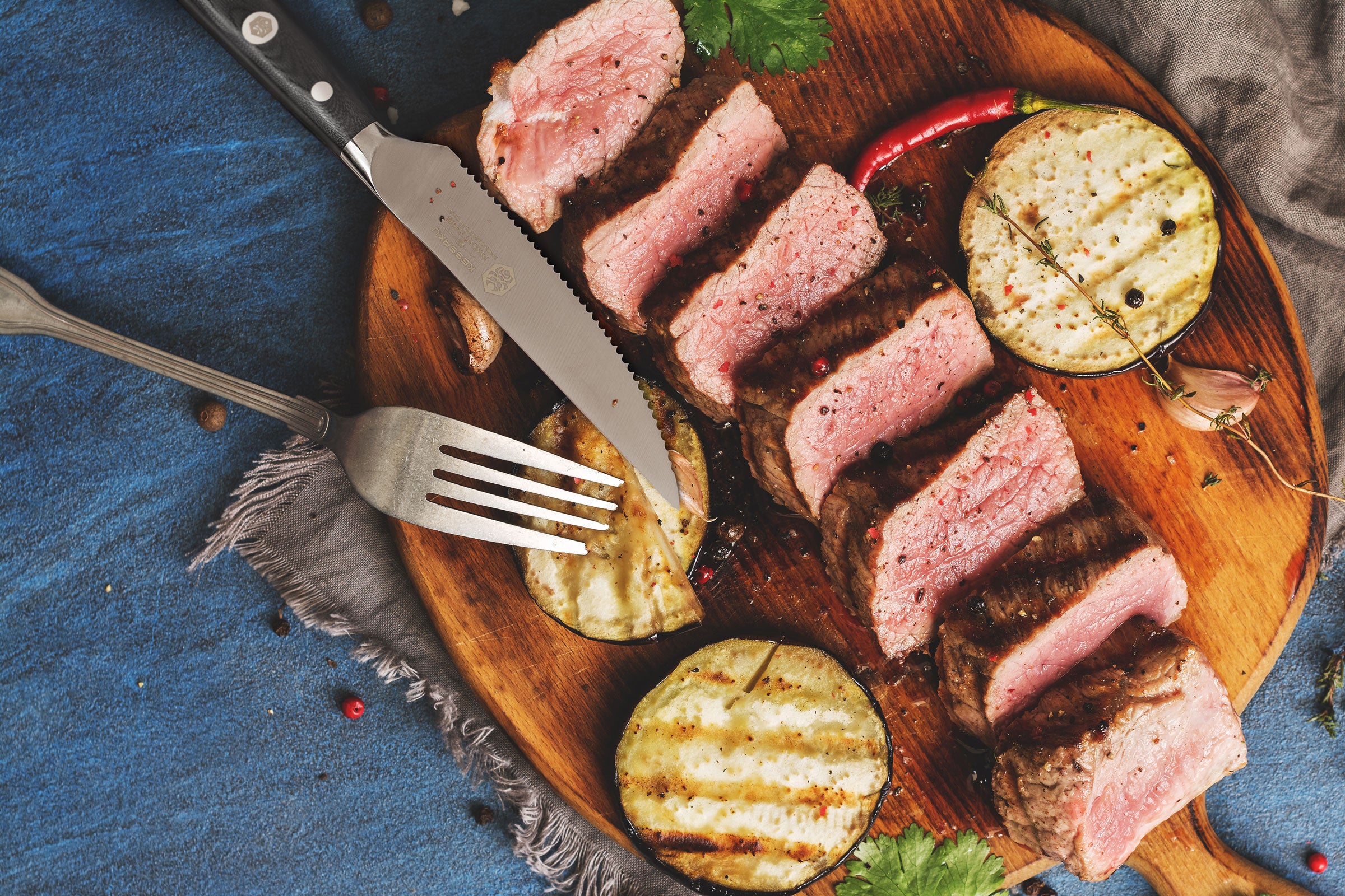 The Dynasty Steak Knife with sliced steak and grilled zucchini