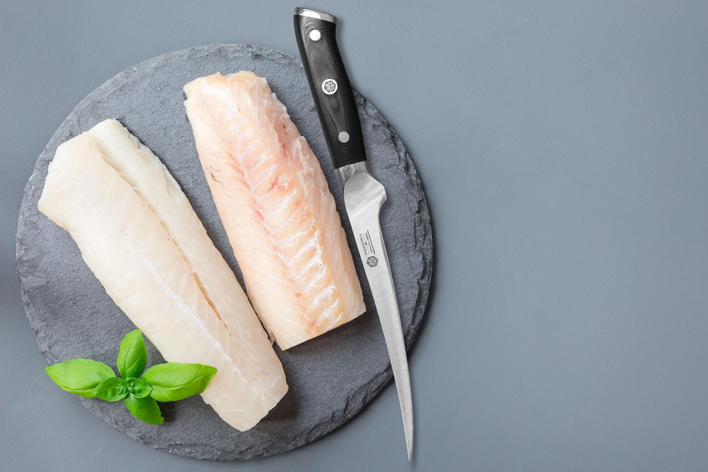 The Dynasty Fillet Knife on slate with perfectly fileted whitefish steaks