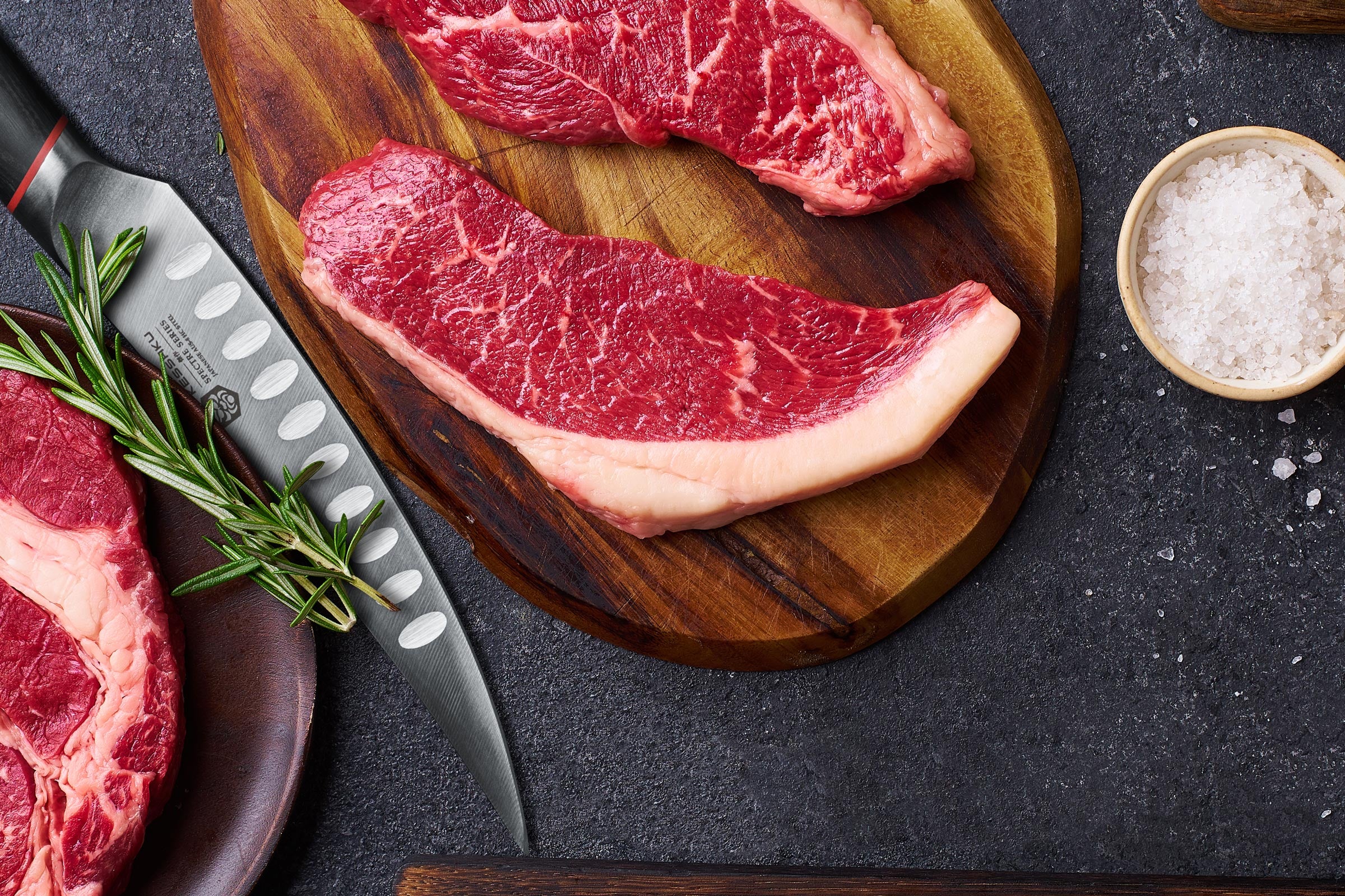 The Spectre Boning Knife next to perfectly trimmed cuts of steak.