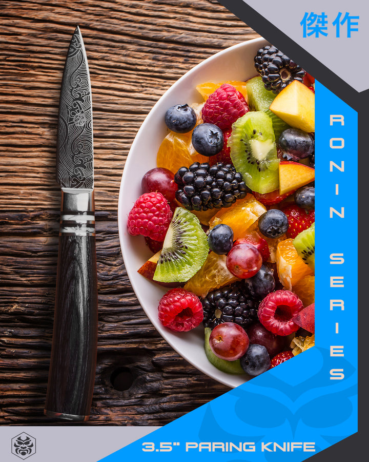 The Ronin Paring Knife with a bowl of mixed fruit including sliced orange kiwi, cubed mango, and berries and grapes