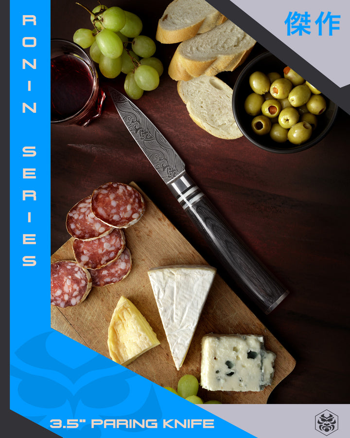 The Ronin Paring knife with slices of cured meat, bread, cheese, green grapes, and a glass of red wine.