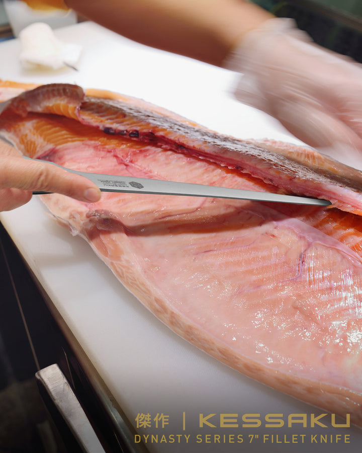 A chef fillets a large fish with the Dynasty Fillet Knife