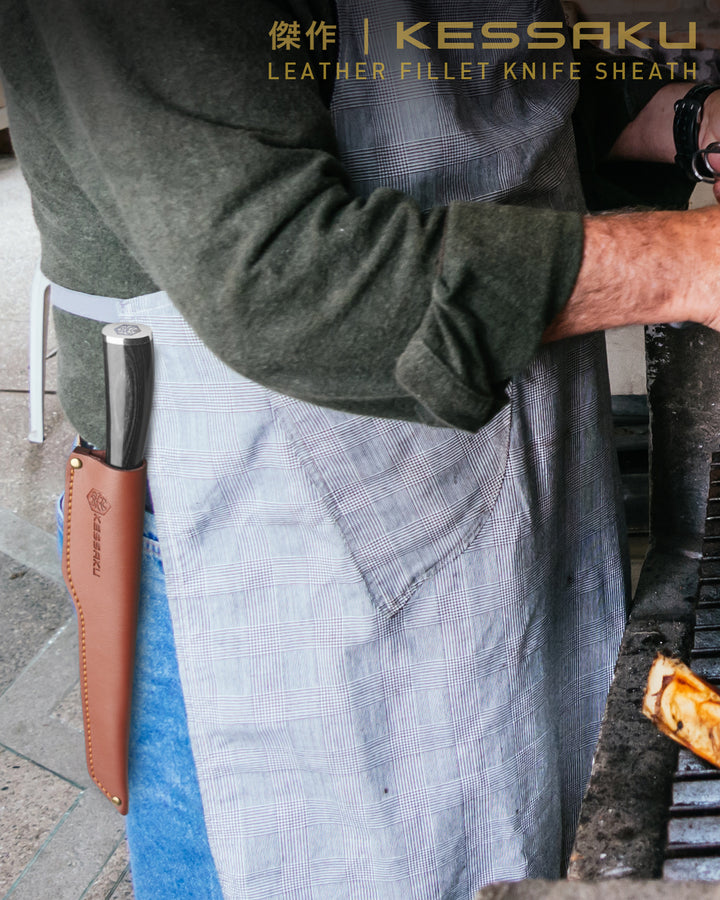 A man barbeques with his Ronin Boning Knife holstered in the Kessaku Leather Knife Sheath